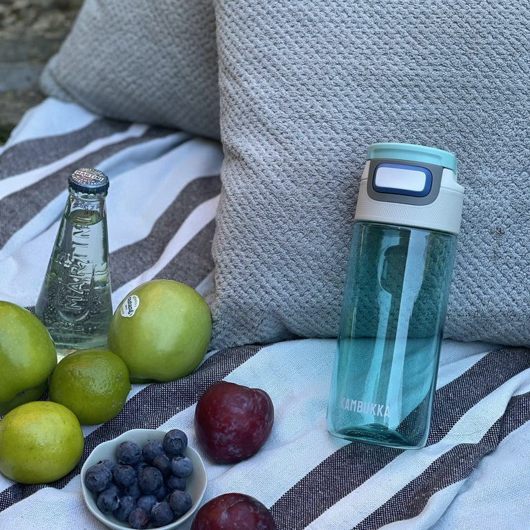 Kambukka Elton 500 ml Ice Green waterfles staat tegen een grijs kussen